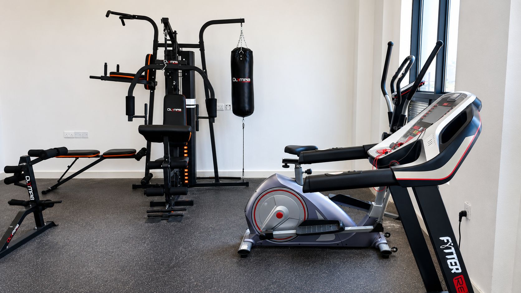 Un gimnasio con bicicleta estática, banco de pesas y saco de boxeo.