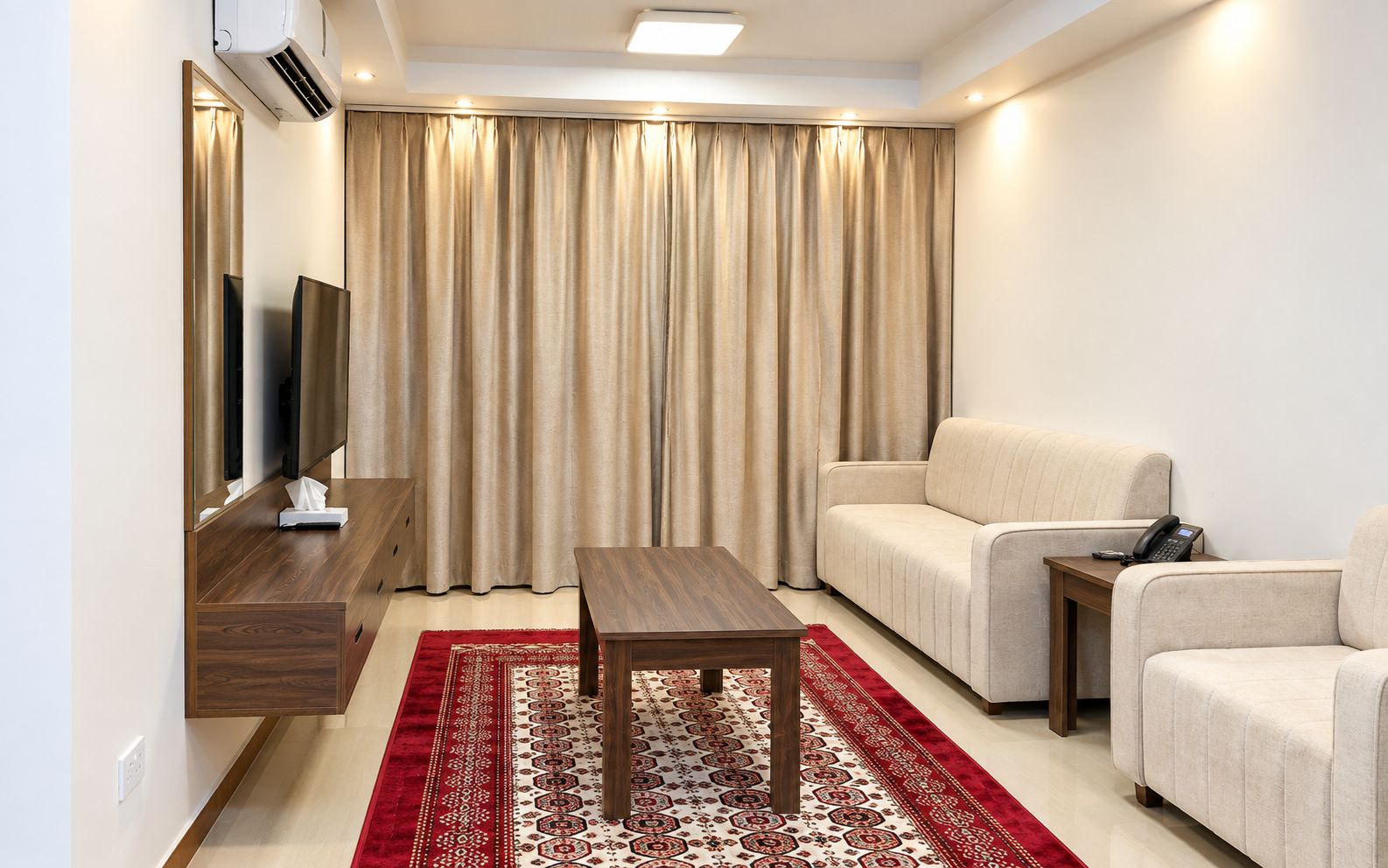 A modern living room with a sofa, a coffee table, a TV, and a telephone.