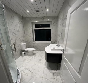 Ein Badezimmer mit Toilette, Waschbecken und Dusche.