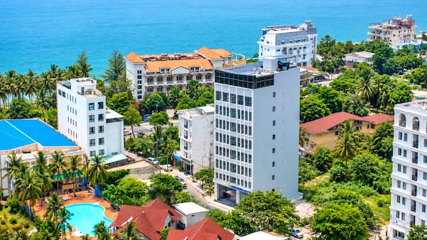 A coastal hotel complex with multiple buildings, a swimming pool, and lush greenery. - Nam Châu Stellar Hotel (Phu Quoc)