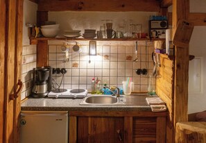 Eine Küche mit Herd, Spüle und Holzschränken.