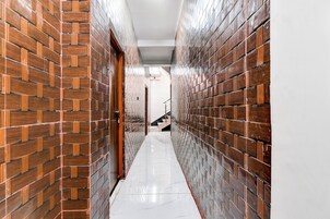 A hallway with brick walls and a shiny tiled floor.