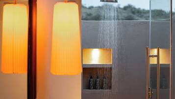 Un baño con ducha, lavabo y espejo.