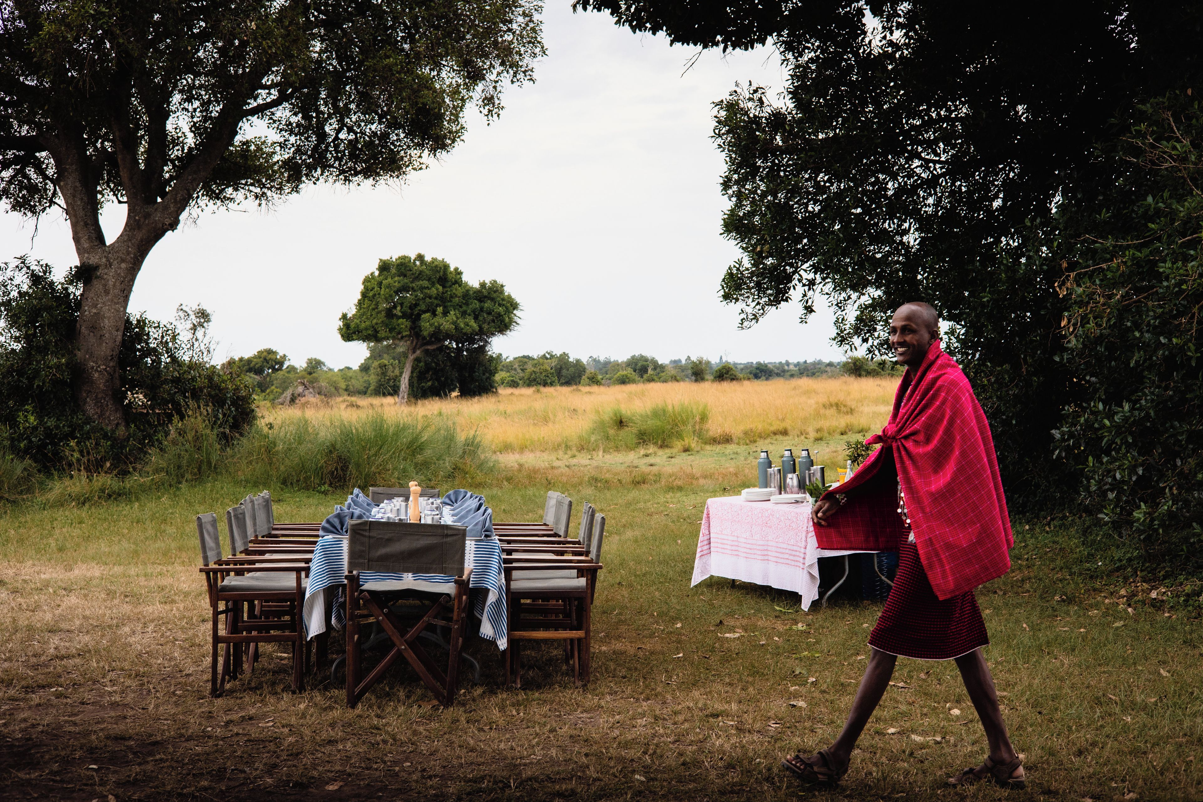 An outdoor dining setup with a table and chairs, surrounded by natural scenery.