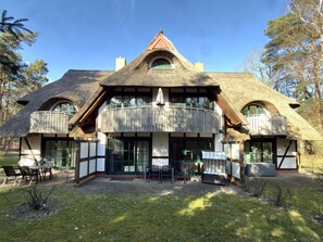 A traditional thatched-roof house with a balcony and a dining area. - Holiday Apartment With 1 Bedroom (Born auf dem Darss)