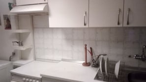 A kitchen with white cabinets, a white countertop, and a tiled backsplash. - 2-brd cozy home Thessaloniki (Thessaloniki)