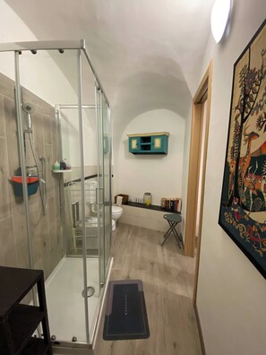 Une salle de bain avec une douche à parois de verre, des toilettes et un lavabo.