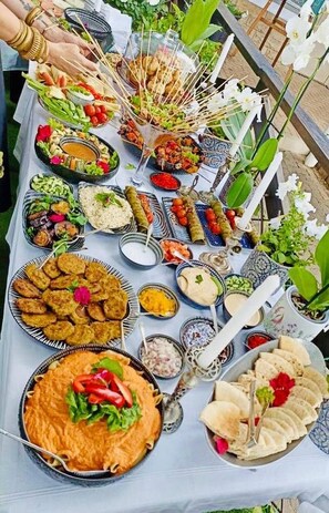 Een tafel met verschillende gerechten, waaronder een grote kom soep, borden met eten en meerdere kleine schaaltjes met bijgerechten.