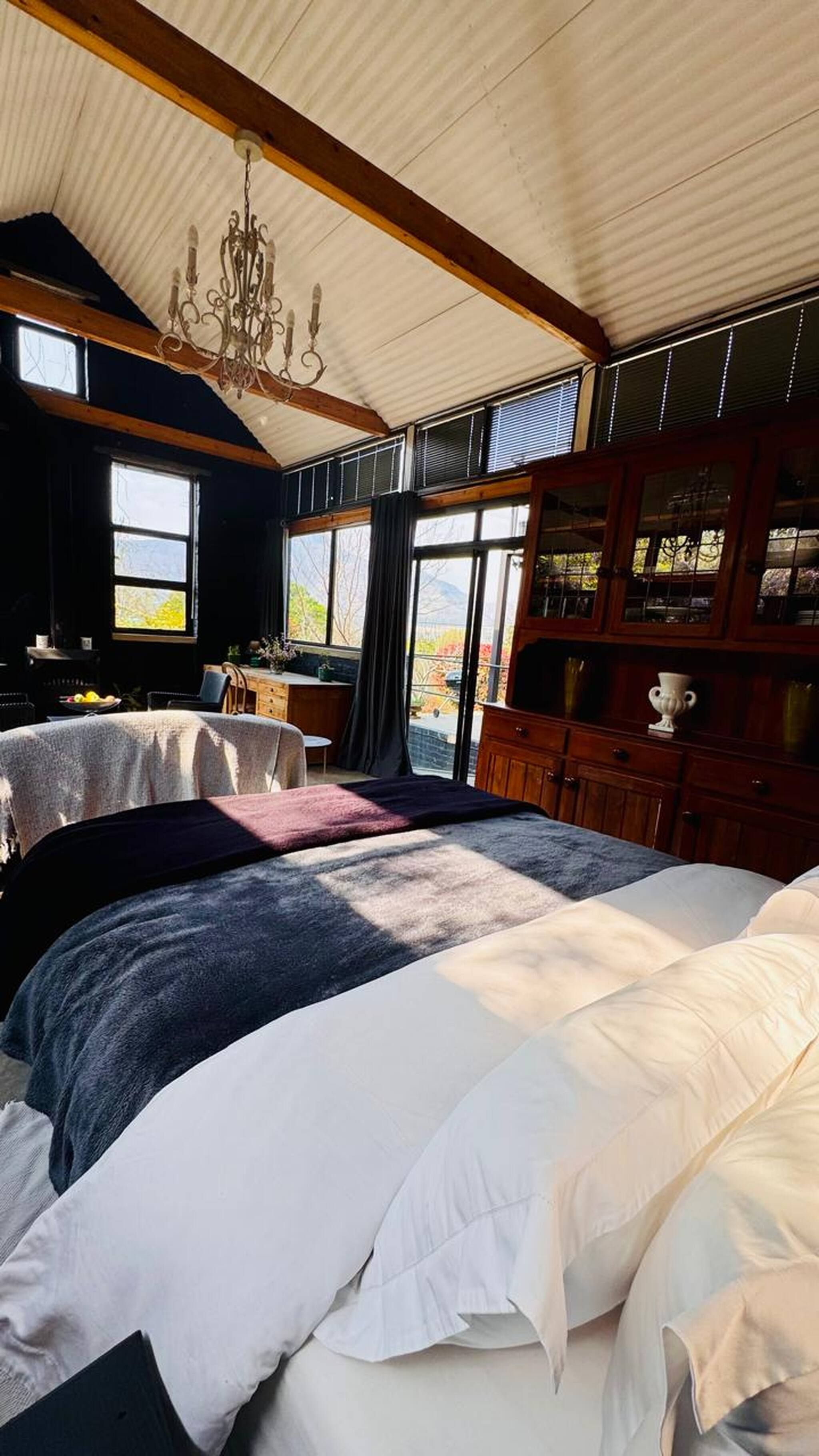 Une chambre à coucher avec un grand lit, un bureau en bois et un lustre.