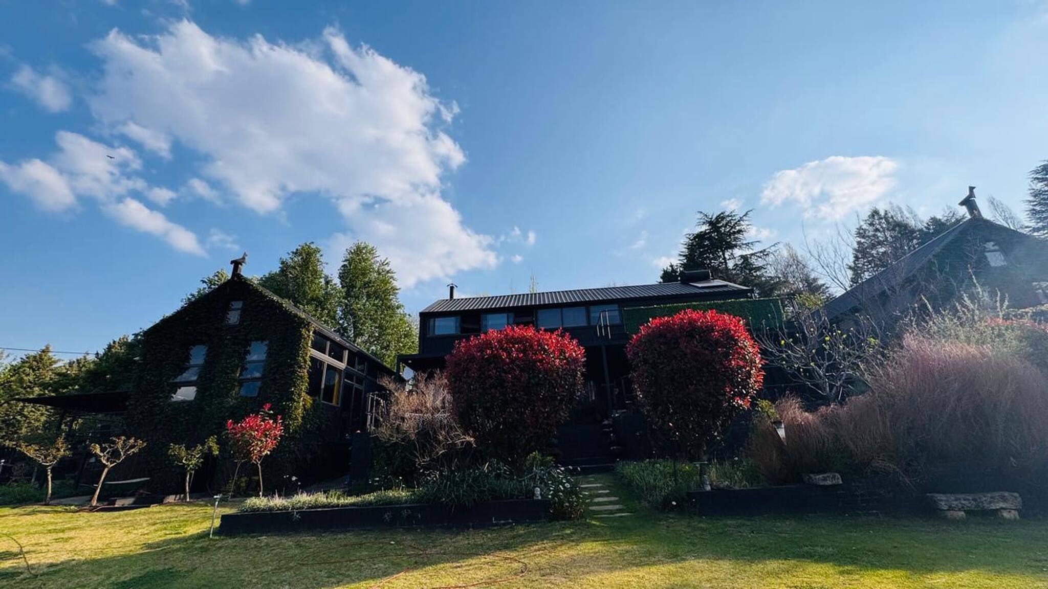 Une maison à deux étages avec un jardin à l’avant.