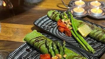 A table set with plates of food, including grilled vegetables and a dish with a patterned design.