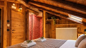 Een houten interieur met een bed, een radiator en een dakraam.