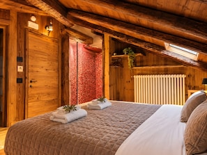 Ein Holzinnenraum mit einem Bett, einem Heizkörper und einem Oberlicht.