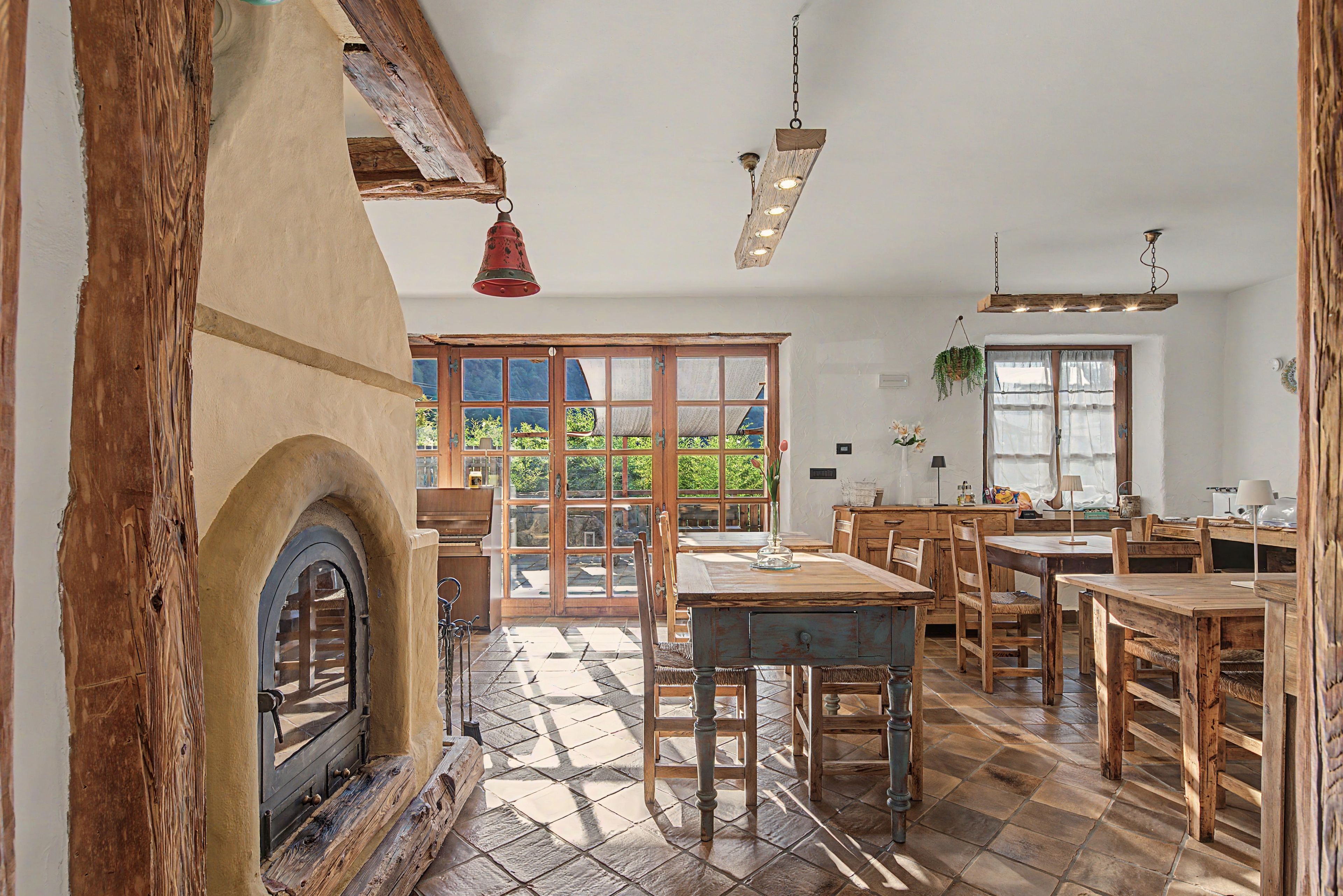 Ein rustikales Interieur mit Kamin, Holzmöbeln und einem großen Fenster.