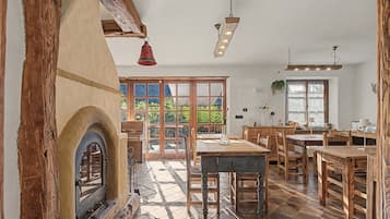 Ein rustikales Interieur mit Kamin, Holzmöbeln und einem großen Fenster.