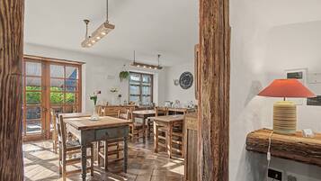 A spacious dining area with wooden furniture and a large window providing natural light.