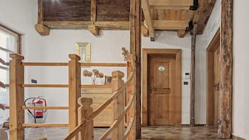 A wooden staircase with a handrail leading to a door with a sign.