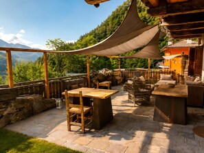 Eine Außenpatio mit Holzmöbeln, Steinböden und Bergblick.