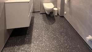 A modern bathroom with a white sink, toilet, and mirror. - Historic Strandgata 36 (Troms)