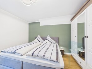 Ein Schlafzimmer mit einem Bett, einem Nachttisch und einem Kleiderschrank.