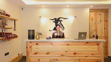 Una recepción con detalles de madera, una computadora portátil y un letrero en la pared que indica una oficina.