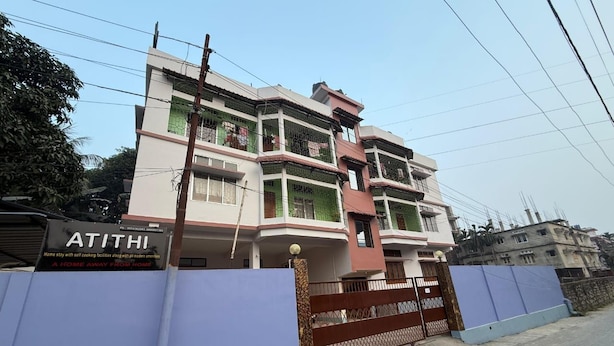 A multi-story residential building with a gated entrance, a signboard, and a clear sky. - Atithi Guest House  (Guwahati)
