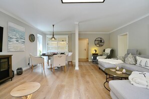 A modern living room with a dining area, a sofa set, and a television. - La Maison Eichenweg App 1 + 3 - Townhouse on Eichenweg (Scharbeutz)