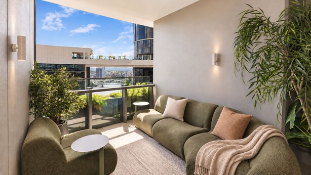 A modern living room with a sectional sofa, a round coffee table, and a small side table. There is a large window offering a view of a cityscape. - Maison Quatre | Brisbane Skyline & River Escape (Brisbane City)