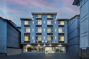 A modern hotel building with a flat roof, multiple windows, and a sign indicating it is a smart hotel. - JoyMaple Court Hotel (Wulingyuan Mark) (Zhangjiajie)
