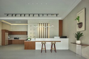 A modern kitchen with a central island, bar stools, and a decorative light fixture. - JoyMaple Court Hotel (Wulingyuan Mark) (Zhangjiajie)