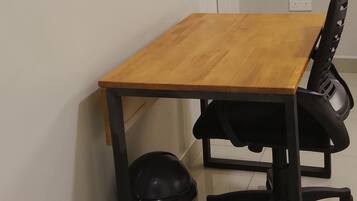 Una sala de conferencias con una mesa de madera, sillas de oficina negras y un cesto de basura negro.