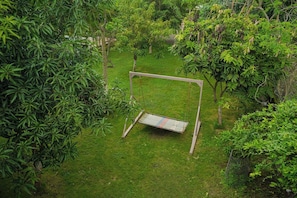 A grassy area with a swing set. - Glorious Gir Resort (Talala)