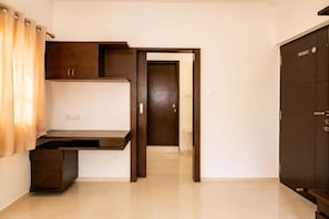 A room with a desk, wardrobe, and a door leading to another room. - Mosaic by Redolive 4bhk Nr Gachibowli Nr Hitec (Hyderabad)