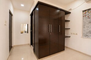 A room with a large wardrobe, a mirror, and a tiled floor. - Mosaic by Redolive 4bhk Nr Gachibowli Nr Hitec (Hyderabad)