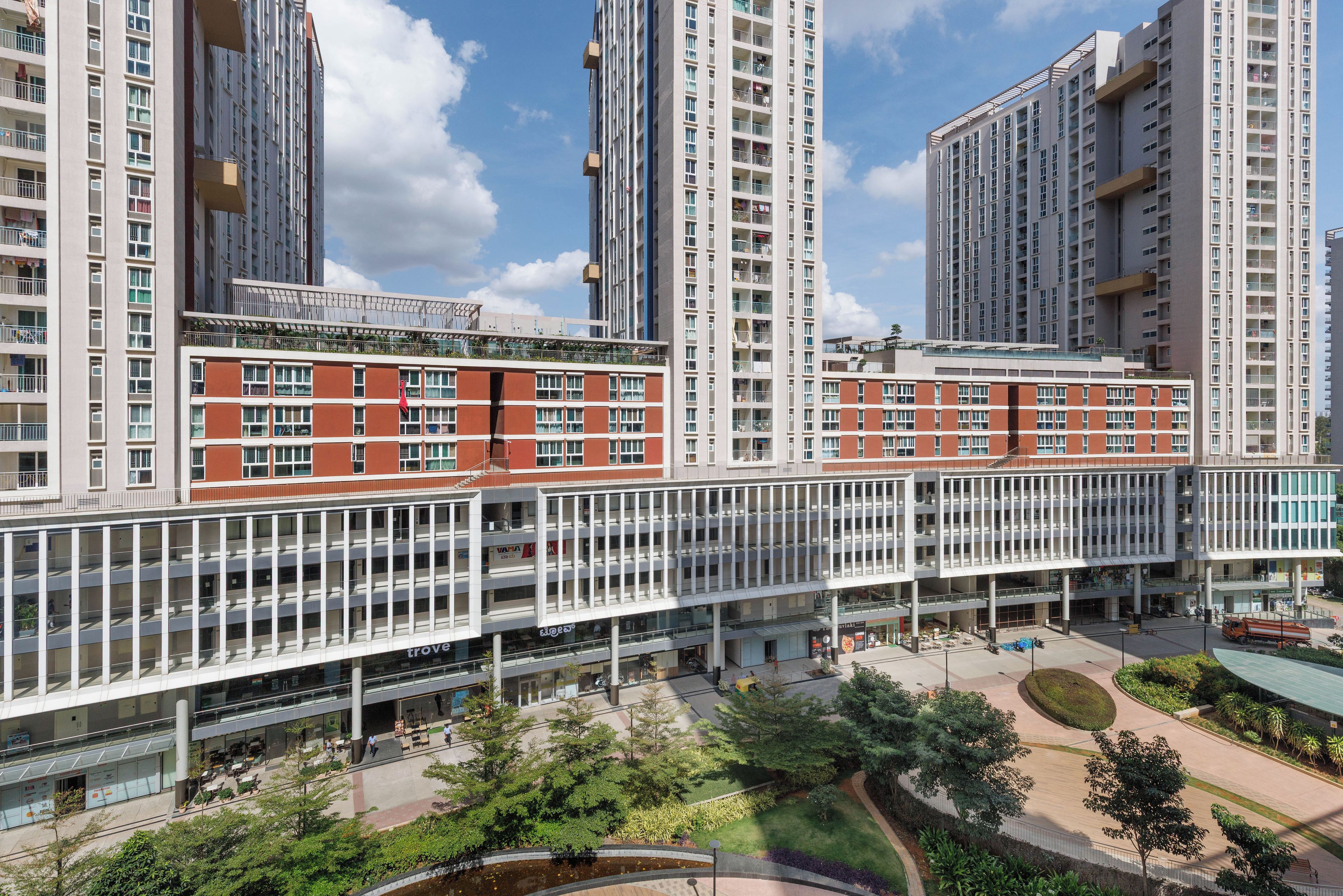 Un immeuble moderne à plusieurs étages, doté de grandes fenêtres et d’un atrium central.