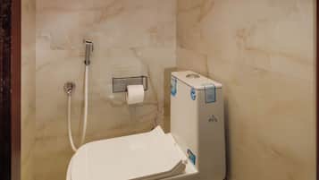 A bathroom with a toilet, a shower, and a towel rack.