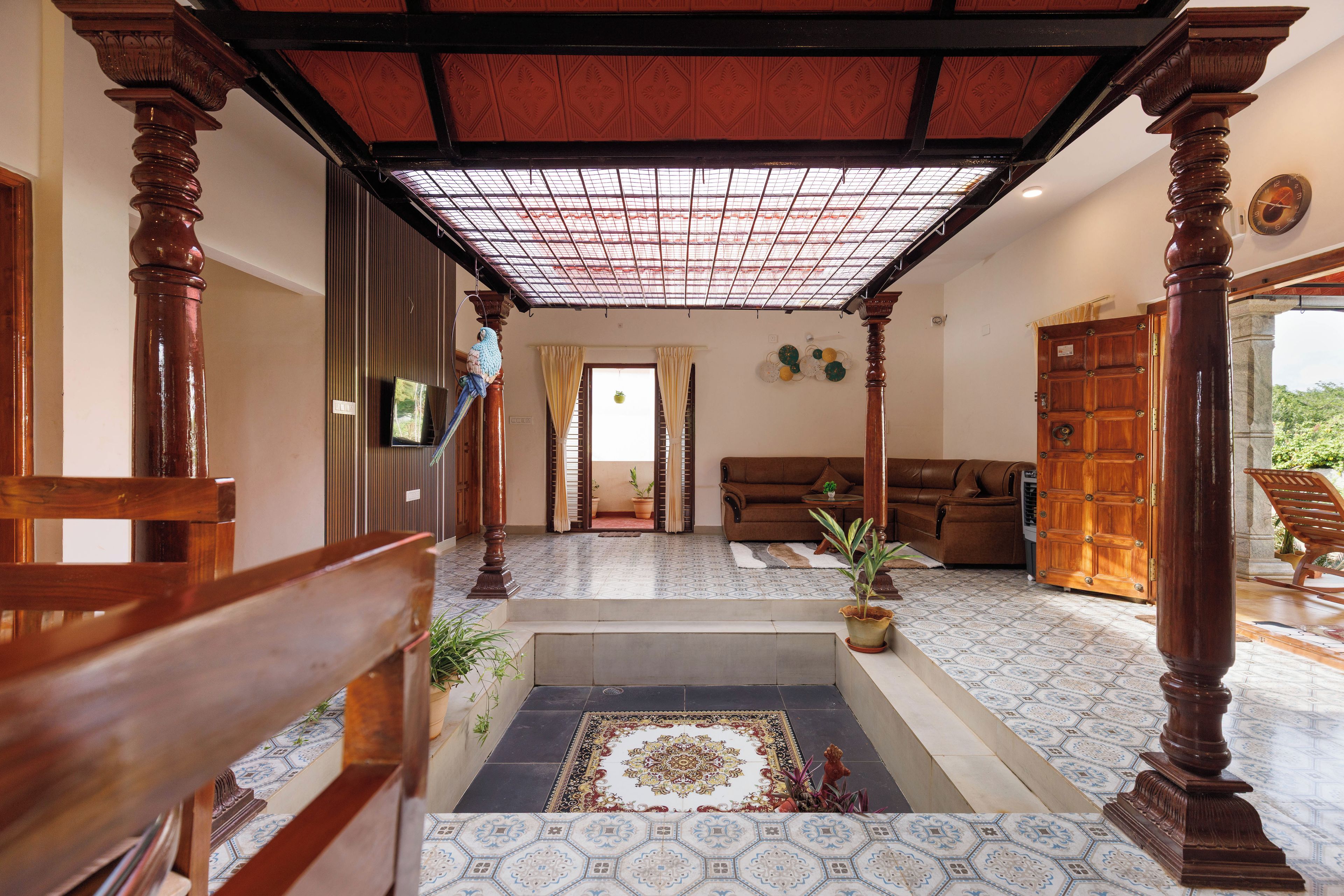 A spacious living area with a patterned floor, a sofa, a coffee table, and a decorative rug.