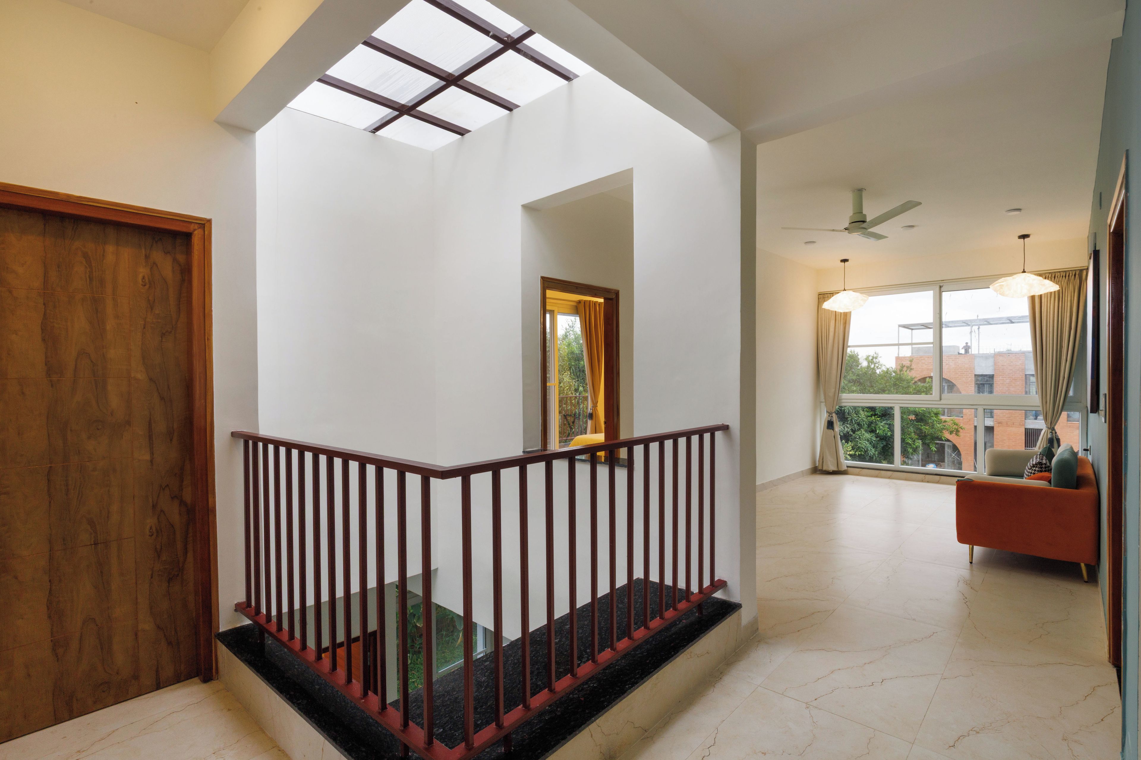 A spacious interior with a staircase, a seating area, and a large window.