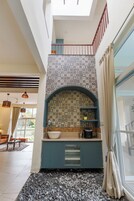 Cozinha moderna com painel de azulejos, pia embutida e máquina de café.