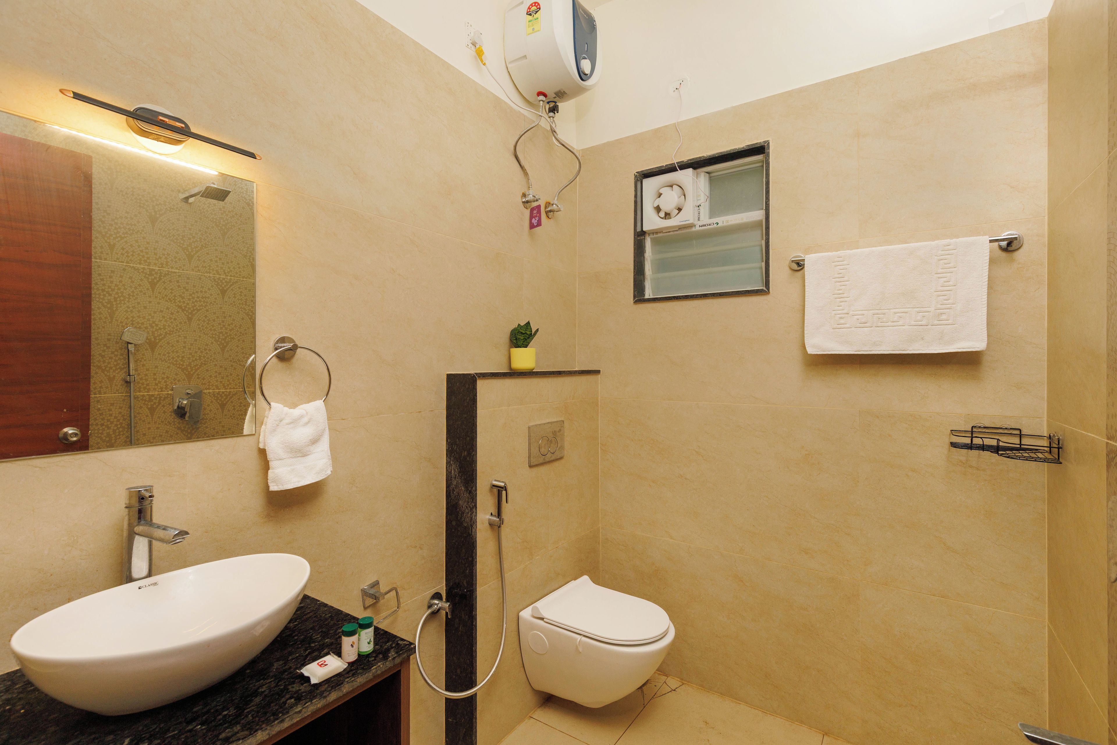 Ein Badezimmer mit einem großen Waschbecken, Toilette und Duschbereich.