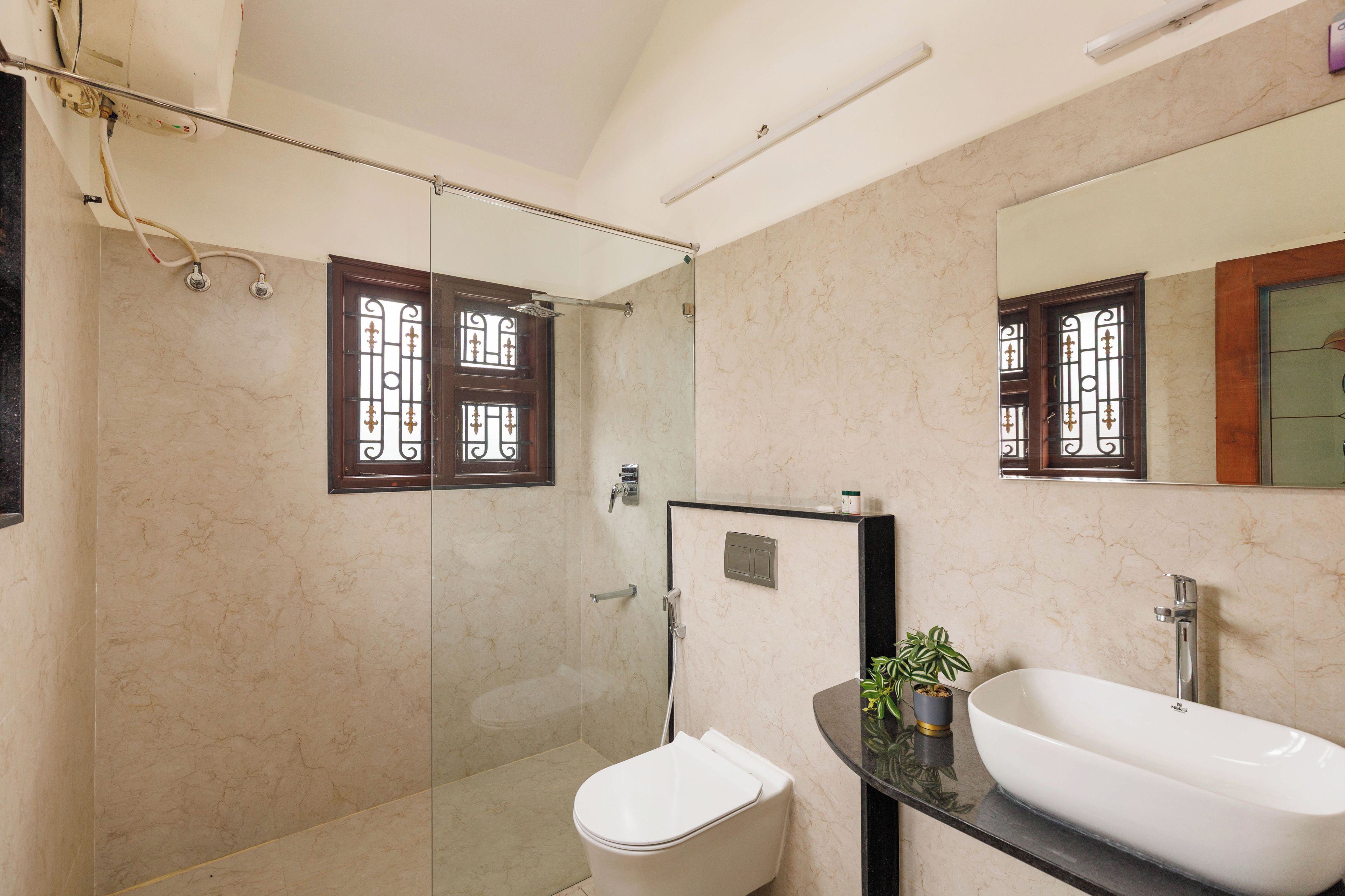 A modern bathroom with a glass shower enclosure, a toilet, and a vanity with a sink.