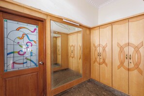 Un armario de madera con puertas espejadas y un ventanal de vitral.