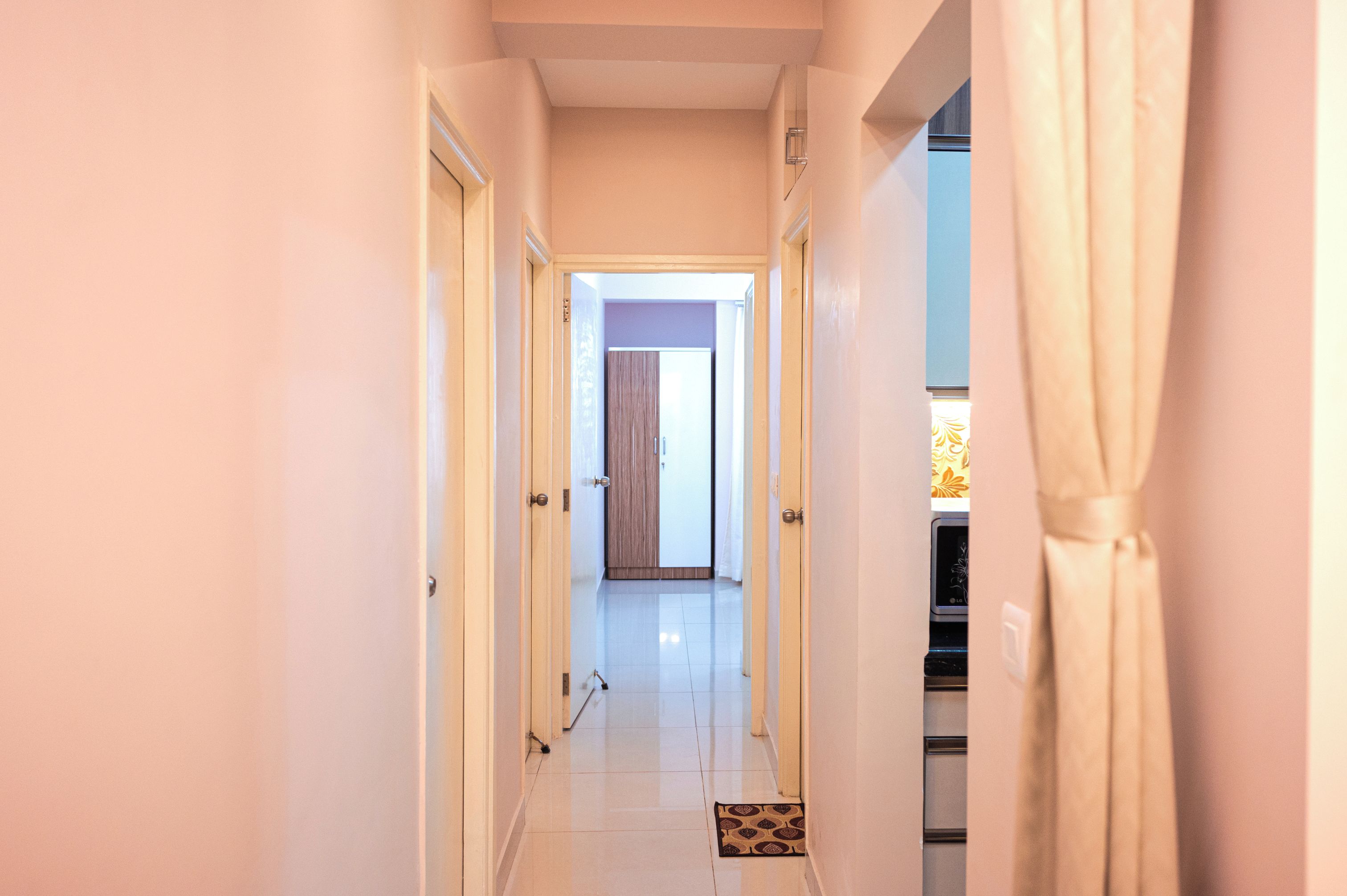 A narrow hallway with doors on both sides leading to different rooms.