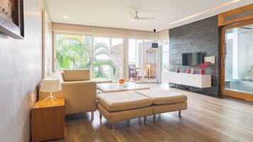 A modern living room with a sofa, a coffee table, and a TV mounted on a brick wall.