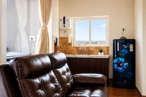 A modern kitchen with a built-in oven, a refrigerator with a floral design, and a window providing a view of the cityscape.