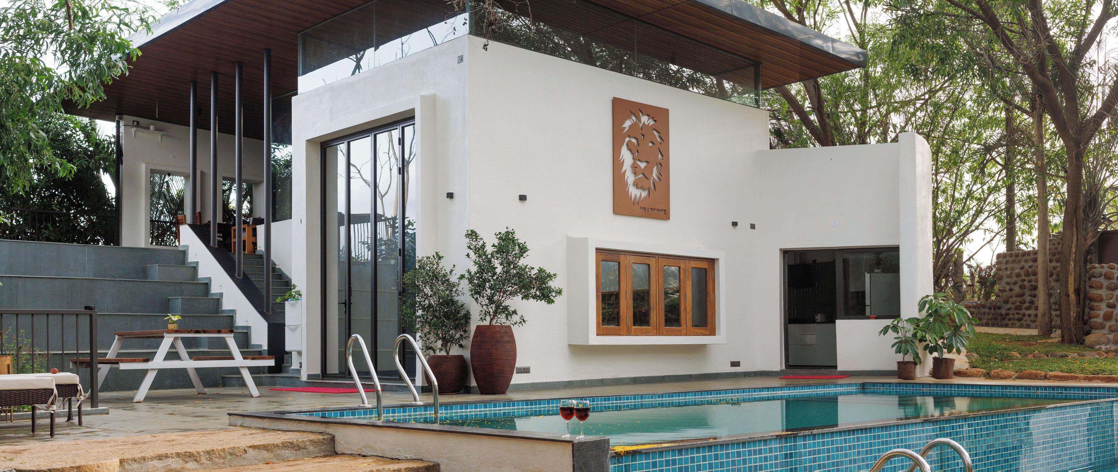 Una casa moderna con piscina, escalera y comedor.