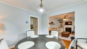 Un espace repas comprenant une table ronde, des chaises et un luminaire suspendu au plafond.