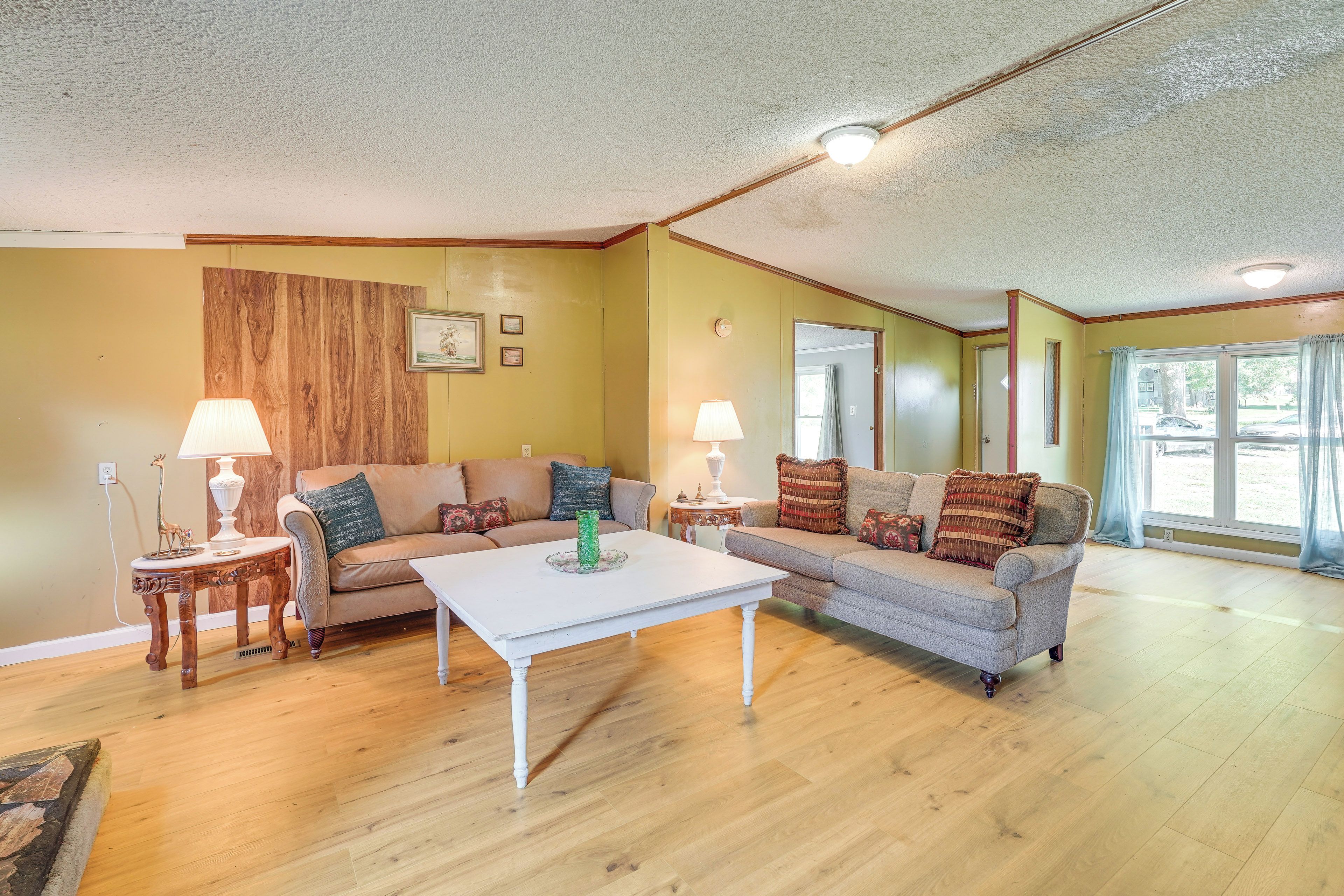 A living room with two sofas, a coffee table, lamps, and a wooden accent wall.