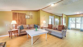 A living room with two sofas, a coffee table, lamps, and a wooden accent wall.