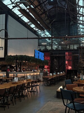 Ein Innenbereich mit Barbereich, Sitzgelegenheiten und einem Schild, auf dem 'BREWDOG' steht.